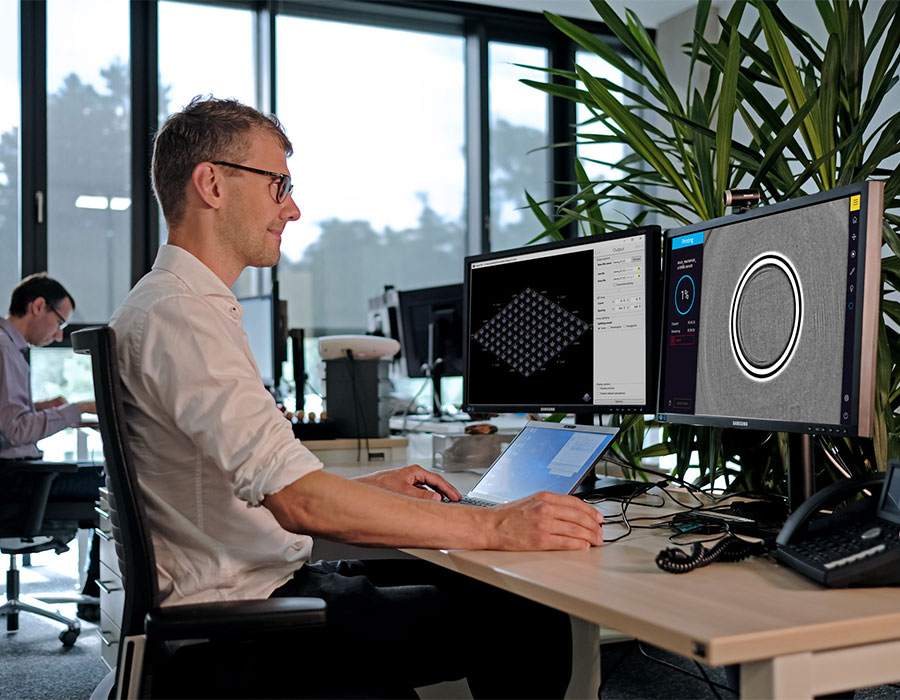 Man sitting on a desk working with nanoConnectX to monitor the Quantum X shape print job