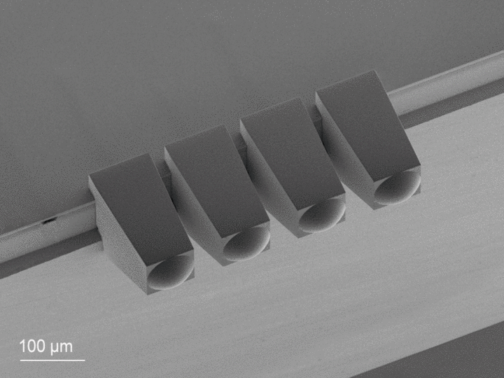 Animated GIF of a SEM image and rendering of mode field shaping microoptics aligned and printed with submicron precision onto the facet of a photonic chip
