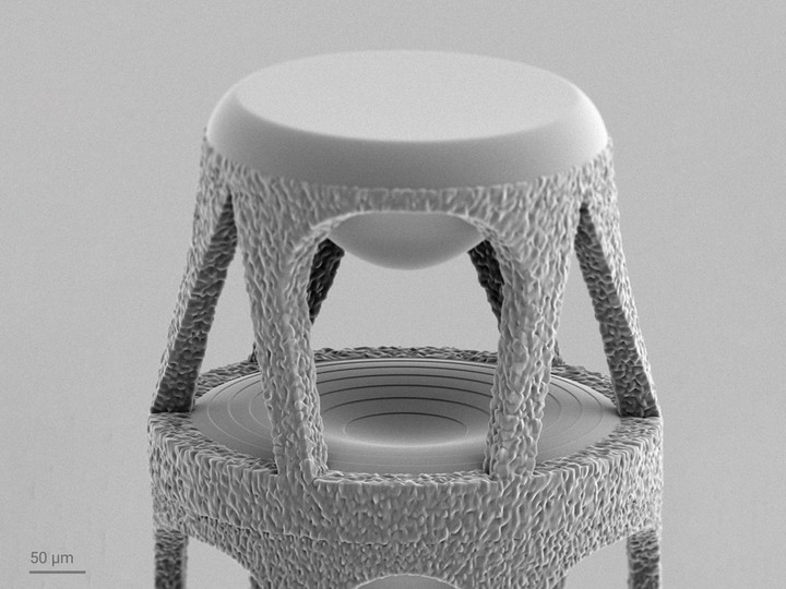 Close-up of the stacked lens system, showing the freeform top lens and the central hybrid lens with its diffractive element